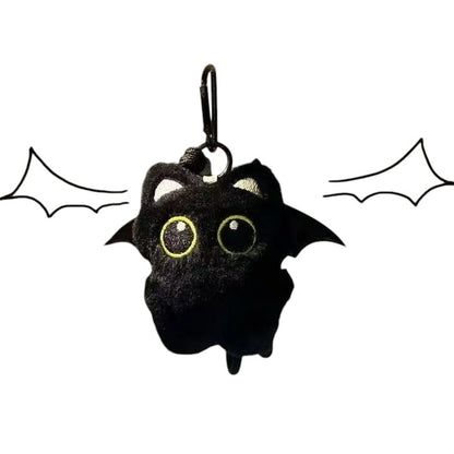 COMFORTH plush black cat keychain charm with large yellow eyes and bat wings. Soft, whimsical accessory.