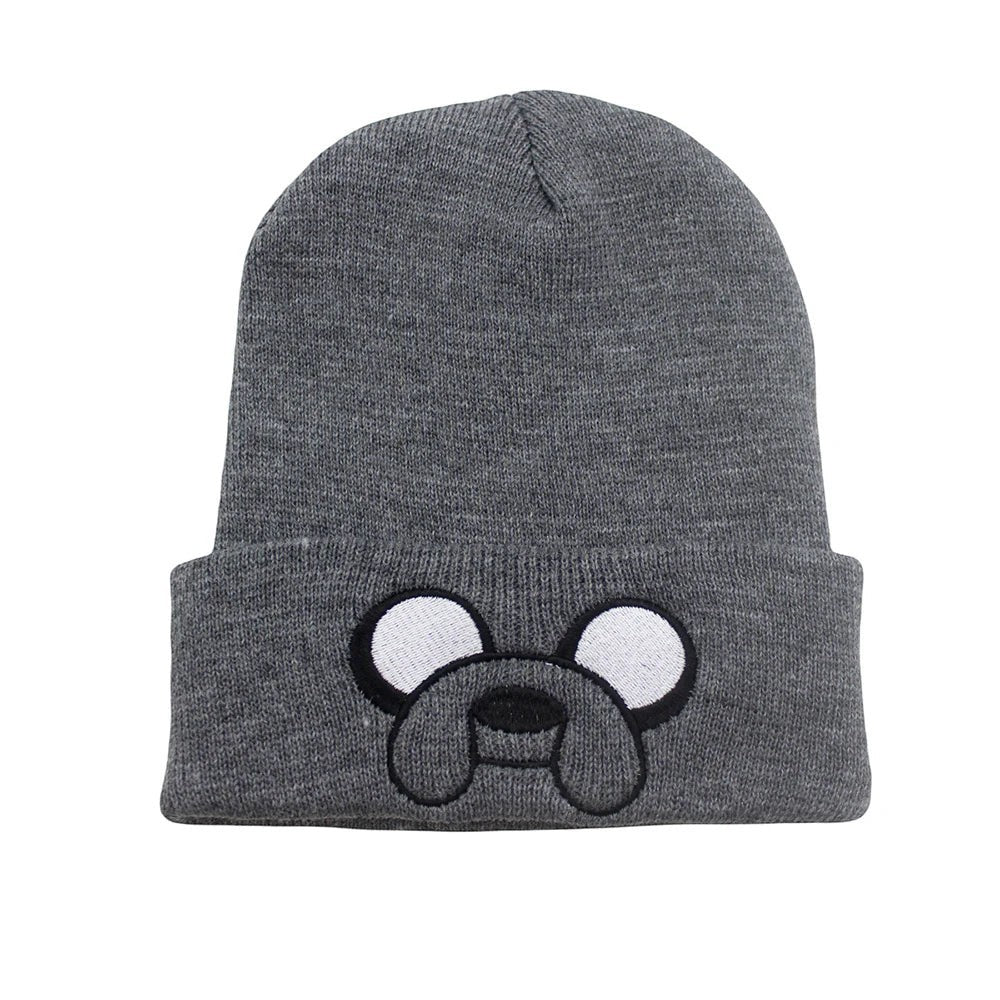 COMFORTHere grey knit beanie hat with embroidered Jake the Dog face from Adventure Time. Features white eyes and black snout.
