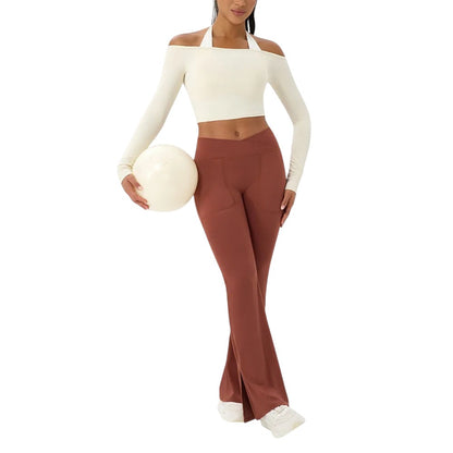 COMFORTHere cream off-shoulder long sleeve athletic crop top with halter neck detail. Nylon-spandex blend.