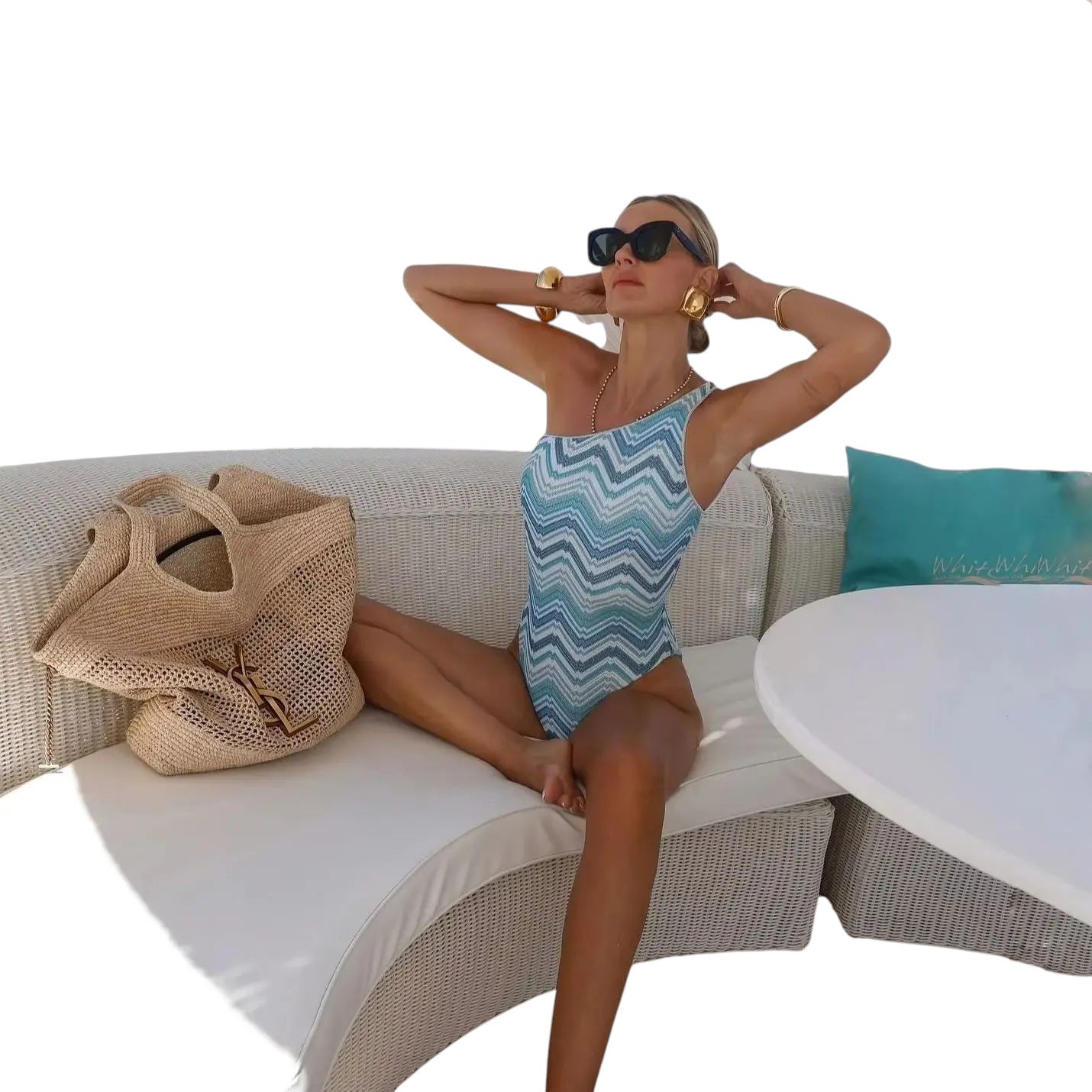 COMFORTHere blue and white chevron knit one-shoulder swimsuit with a high leg cut. Model wears sunglasses and gold jewelry.