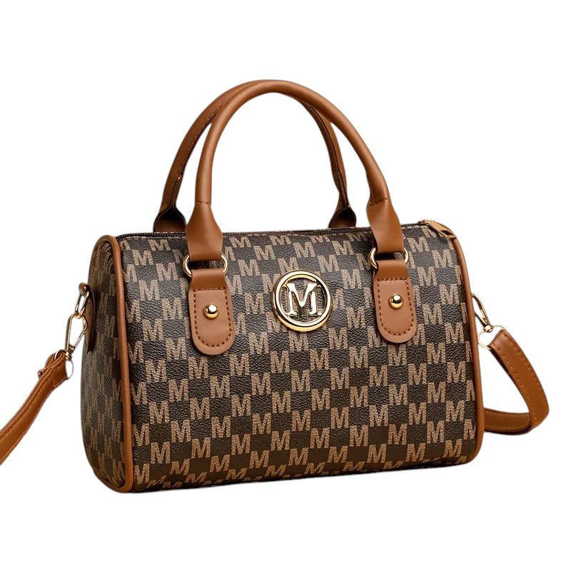 COMFORTHere Monogram Barrel Handbag with shoulder strap, brown and tan monogram print, gold M emblem, top handles and crossbody strap.