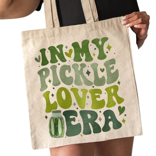COMFORTHere In My Pickle Lover Era canvas tote bag with green text and pickle jar graphic. Natural canvas material.
