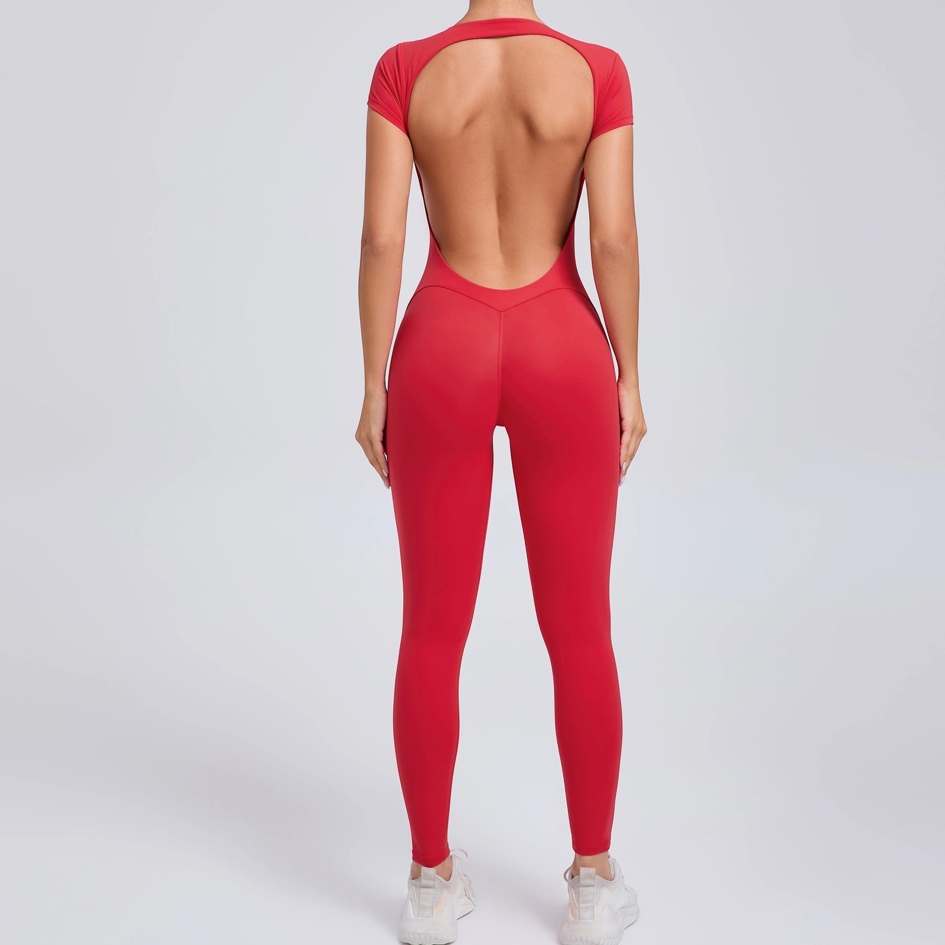 COMFORTHere red short sleeve full length activewear bodysuit with a deep open back and v-shaped waistline.