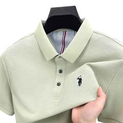 COMFORTS light beige pique knit short sleeve polo shirt with embroidered logo and striped inner collar.