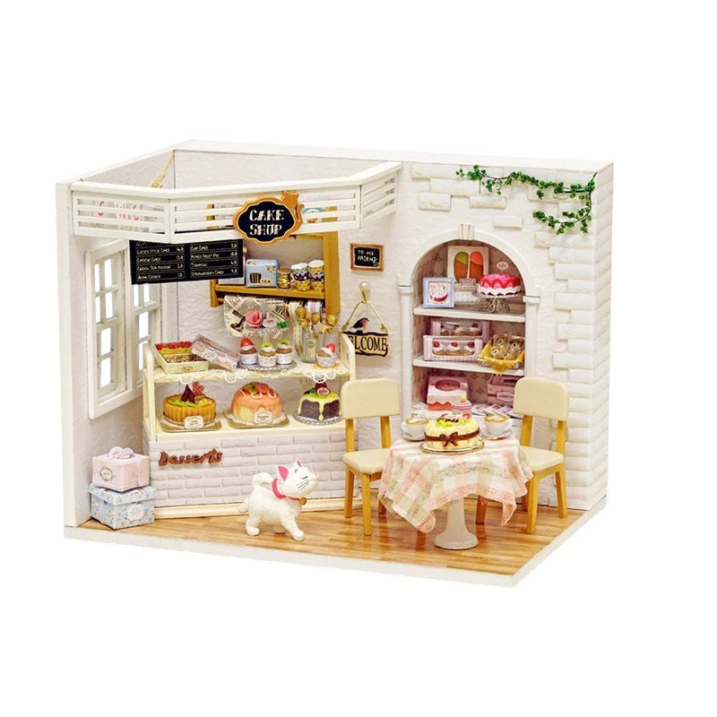 COMFORTS miniature dollhouse building kit, a charming bakery scene with detailed cakes, pastries, and a white cat figurine.