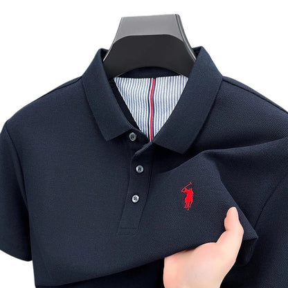 COMFORTS navy blue pique knit short sleeve polo shirt with red embroidered logo and striped inner collar.